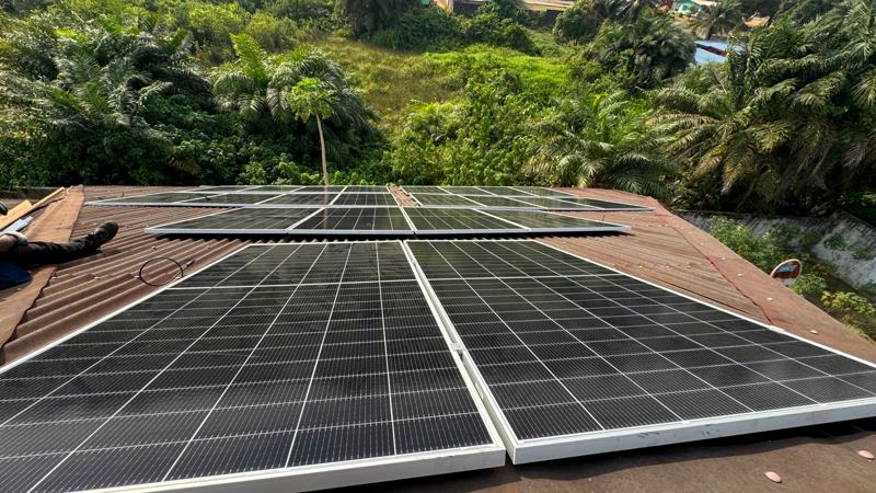 Rooftop solar array on a clinic building surrounded by greenery