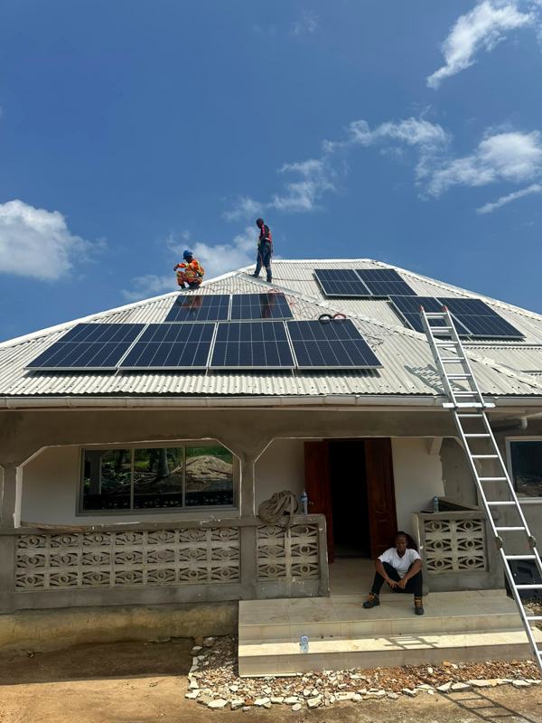 Ladder against a house with technicians installing panels above