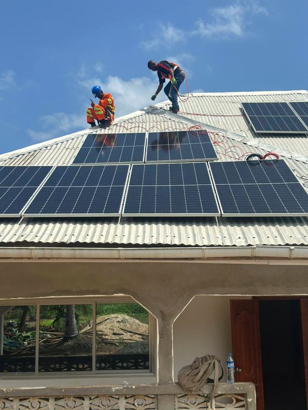 Technicians installing solar panels on a private home in Liberia