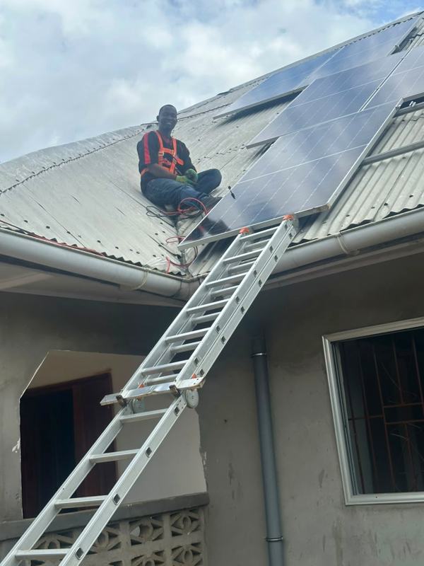Technician climbing to the roof on a long ladder