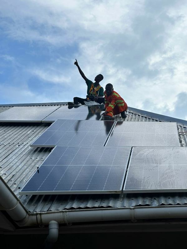 Installer waving from a finished rooftop array
