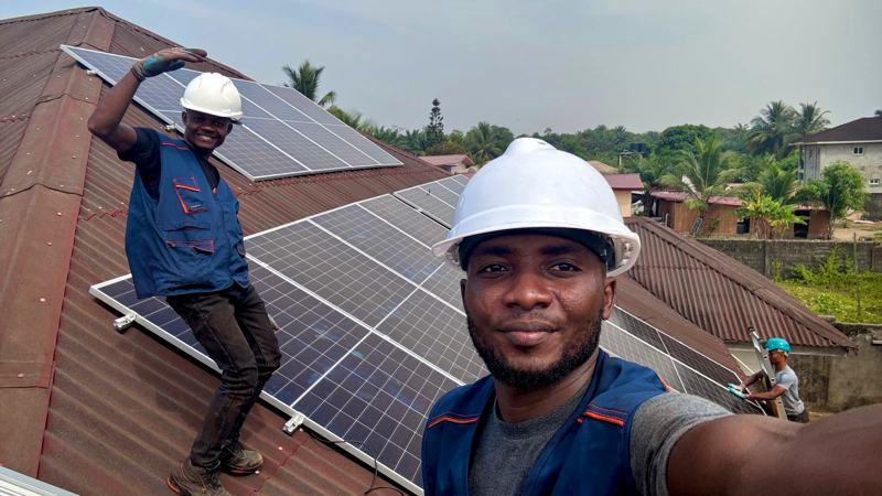 Crew selfie on a red roof during an installation