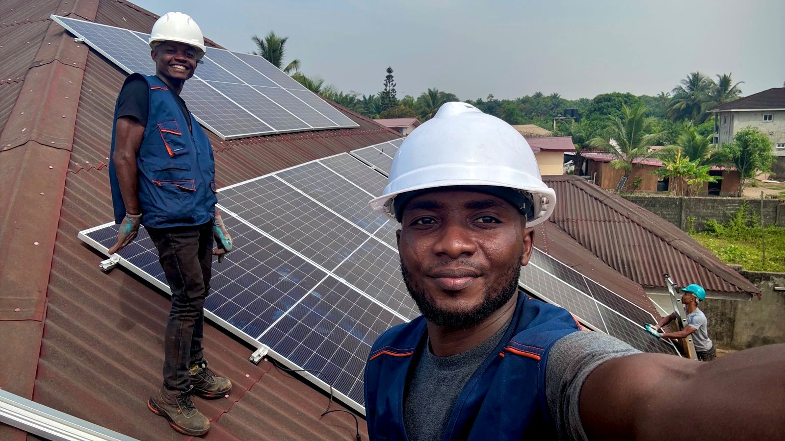TC Energy installation team smiling on a rooftop in Monrovia